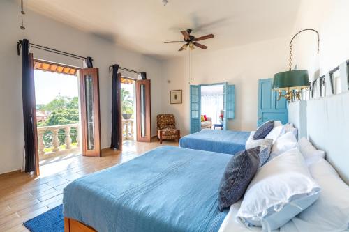 a bedroom with two beds and a balcony at Plaza Chapala Hotel in Chapala