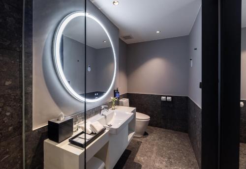 a bathroom with a sink and a mirror at Travelodge Nimman in Chiang Mai