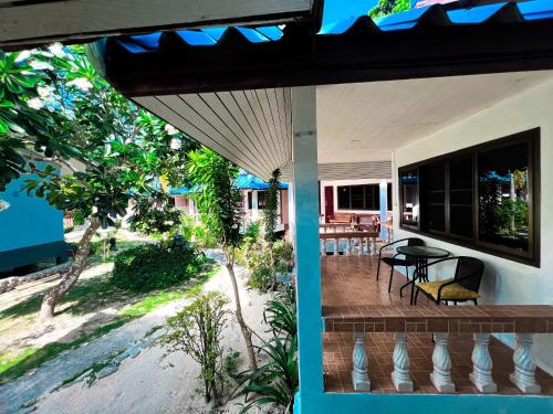 a porch of a house with a table and chairs at Ibiza Bungalows in Haad Yao