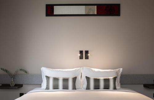 a white bed with two pillows on top of it at Travelodge Nimman in Chiang Mai