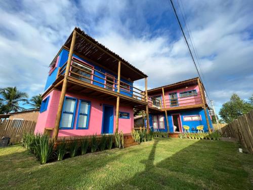 una casa colorida con una valla delante en EcoFlats Caraiva en Caraíva