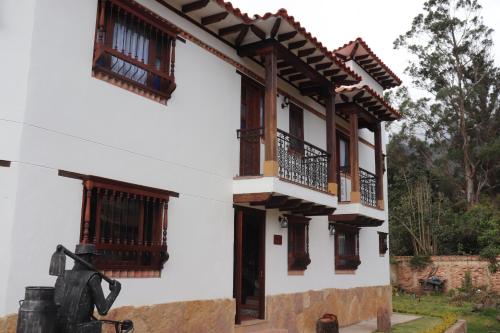 a house with a statue in front of it at Casa El Retiro - Villa de Leyva in Villa de Leyva