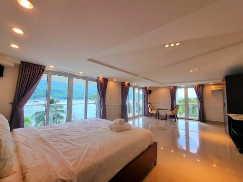 um quarto com uma cama grande e janelas grandes em Promotion summer vacation, Ocean Villa Nha Trang 600m2 with 7 Bedrooms, Karaoke, BBQ em Nha Trang