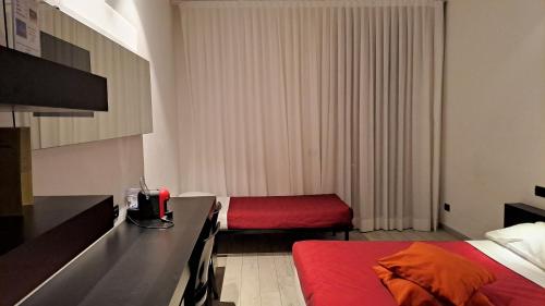 a small hotel room with two beds and a red bed sidx sidx sidx at Blue Shades Hotel in Pisa