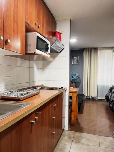 a kitchen with a sink and a microwave at Departamento Hoome Studio in Santiago