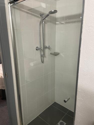 a shower with a glass door in a bathroom at Lismore Fair Dinkum Motel in Lismore