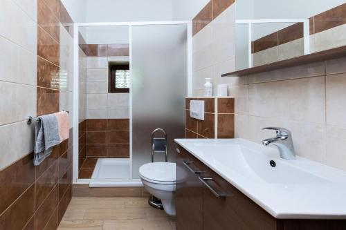 La salle de bains est pourvue de toilettes, d'un lavabo et d'une douche. dans l'établissement Apartments Zeljko, à Kampor