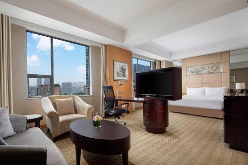 a hotel room with a bed and a flat screen tv at Holiday Inn Chengdu Century City-EastTower in Chengdu