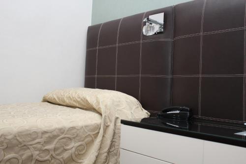 a small room with a bed and a phone on a counter at Ayacucho Palace Hotel in Buenos Aires