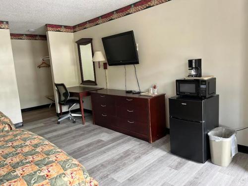una camera d'albergo con letto, TV e scrivania di Yorktown Motor Lodge a Yorktown