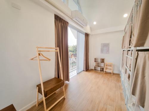 a room with a staircase and a large window at Bloomin' Moon hostel & cafe, Chiang Mai Old Town in Chiang Mai