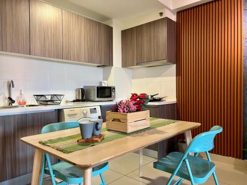 a kitchen with a wooden table and blue chairs at Cozy Hyve Soho Suites in Cyberjaya