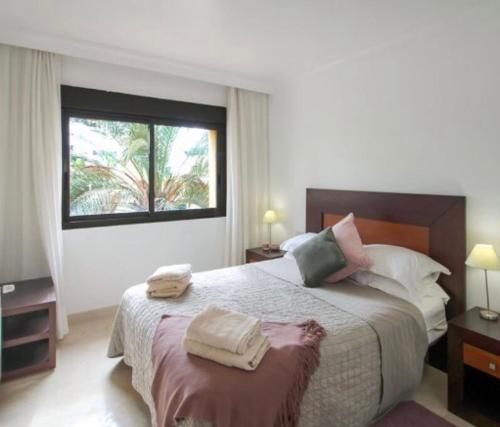 1 dormitorio con 1 cama grande y 2 toallas. en Penthouse Apartment - Roda Golf & Beach Club, en San Javier