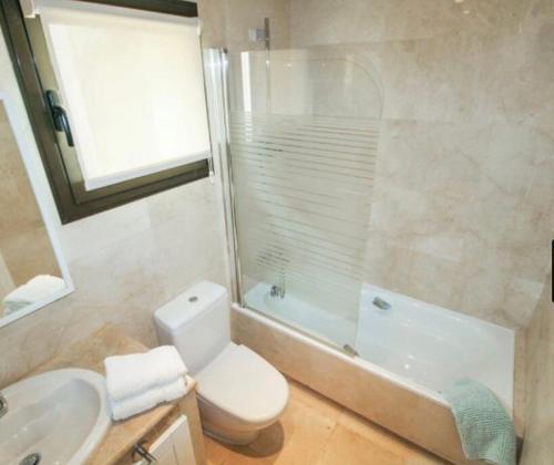 y baño con aseo, lavabo y ducha. en Penthouse Apartment - Roda Golf & Beach Club, en San Javier
