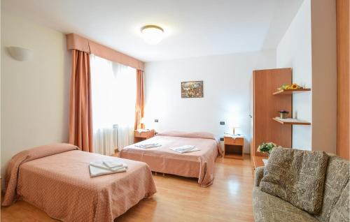 een hotelkamer met 2 bedden en een stoel bij 3 Bedroom Stunning Apartment In Roncegno Terme in Marter di Roncegno