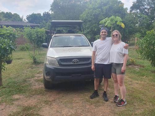 a man and a woman standing in front of a car at Ceylon Resort in Wilpattu