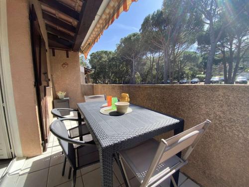 une table et des chaises sur le balcon d'une maison dans l'établissement Appartement 2P avec Mezzanine, Balcon, Parking Privé - À 200m de la Plage de la Nartelle - FR-1-226-523, à Sainte-Maxime