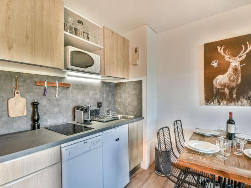 une cuisine et une salle à manger avec une table et des chaises dans l'établissement Appart rénové 4 pers, centre Les Gets, proche remontées, balcon, parking - FR-1-685-70, aux Gets