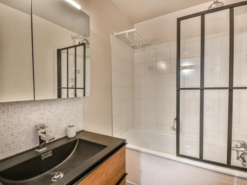 une salle de bain avec un lavabo et une baignoire dans l'établissement Appart rénové 4 pers, centre Les Gets, proche remontées, balcon, parking - FR-1-685-70, aux Gets