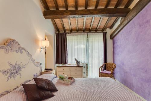 um quarto com uma cama grande e uma janela em Relais Antico Borgo San Lorenzo em Poggibonsi