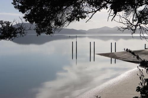a view of a lake with poles in the water at Luxury Waterfront in One Tree Point