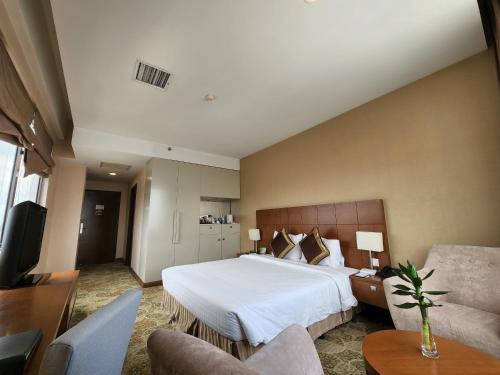 a hotel room with a large bed and a couch at AURORA Hotel Plaza in Bien Hoa