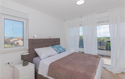 ein Schlafzimmer mit einem Bett und einem großen Fenster in der Unterkunft Pet Friendly Home In Sibenik With Heated Swimming Pool in Šibenik