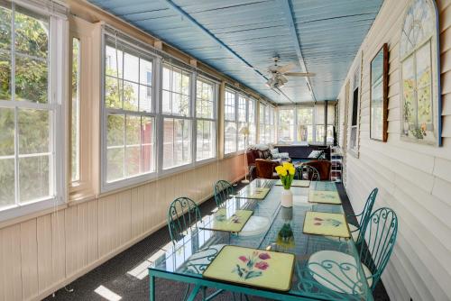 a dining room with tables and chairs and windows at Historic Warren Vacation Rental Walk to Beaches! in Warren