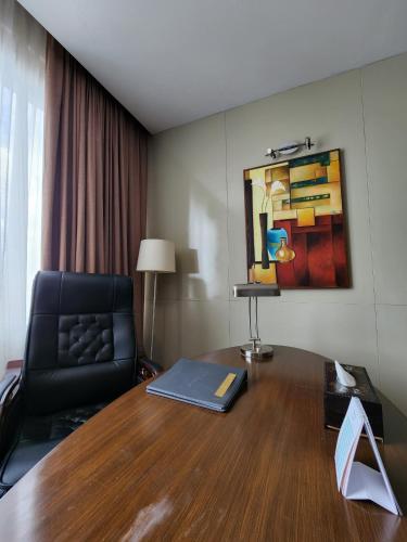 a room with a desk with a chair and a couch at AURORA Hotel Plaza in Bien Hoa