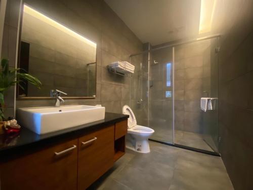 uma casa de banho com um lavatório, um chuveiro e um WC. em Guan Guan Xiang Hu em Guanshan