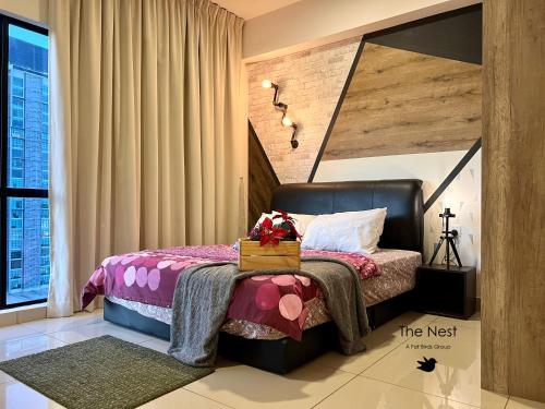 a bedroom with a bed with a box on it at Cozy Hyve Soho Suites in Cyberjaya