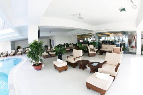 a hotel lobby with a pool and tables and chairs at AURORA Hotel Plaza in Bien Hoa