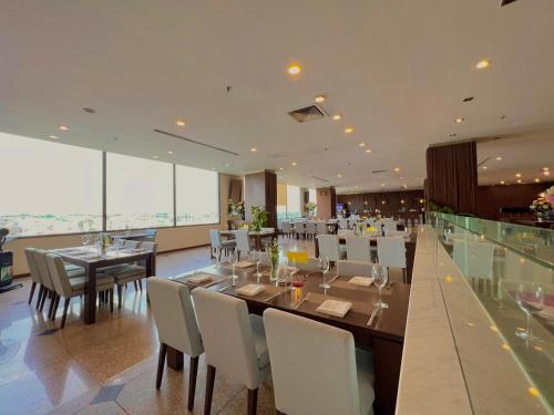 a dining room with a long table and chairs at AURORA Hotel Plaza in Bien Hoa