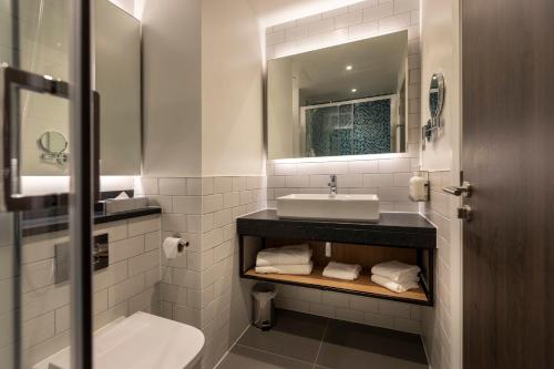 a white bathroom with a sink and a mirror at Holiday Inn London Sutton by IHG in Sutton