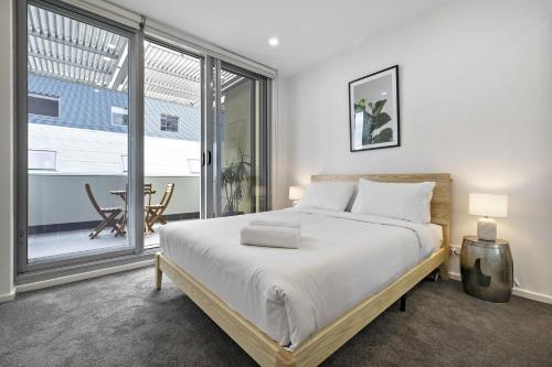 sypialnia z łóżkiem i dużym oknem w obiekcie Meadow - The York Skyline Apartment w mieście Adelaide