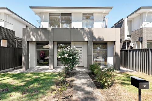 a white house with a fence at Clover - The Split-Level Sanctuary in Payneham South in Norwood