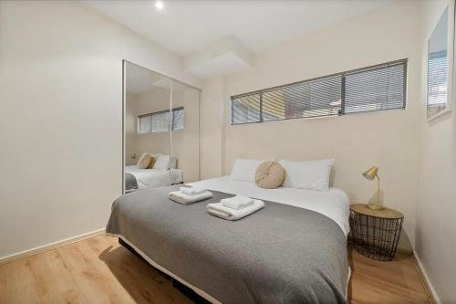 1 dormitorio con 1 cama grande y 2 toallas. en Azalea - Rundle Mall Edge Residence on York, en Adelaida