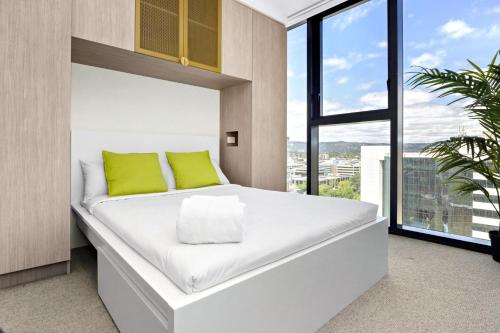 1 cama blanca grande en una habitación con ventana en Iris - The Skylight Escape Apartment, en Adelaida