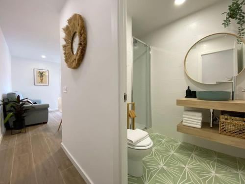 ein Bad mit einem WC und einem Spiegel in der Unterkunft ´WALK TO CAMP NOU´ STYLISH 3BD SMART TV Wifi in Hospitalet de Llobregat