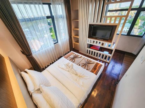 Habitación pequeña con cama y TV. en HOTEL KEIO YANGON, en Rangoon Ahlone