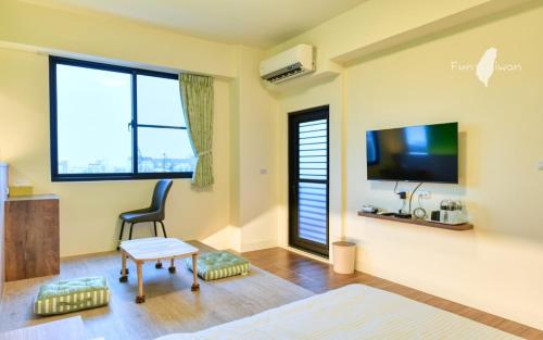 een woonkamer met een stoel en een flatscreen-tv bij 漫活時光民宿 Leisure Living in Baisha