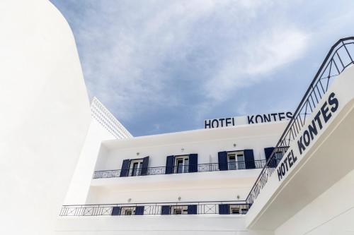 a white hotel with a sign on the top of it at Hotel Kontes Comfort in Parikia