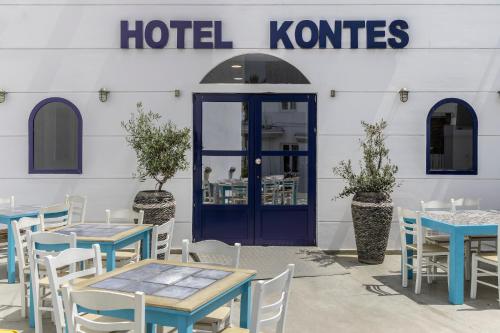 a restaurant with tables and chairs and a blue door at Hotel Kontes Comfort in Parikia