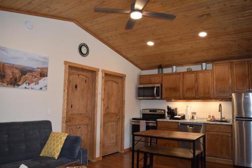 a kitchen with wooden cabinets and a ceiling fan at Log Cottages at Bryce Canyon #3 in Cannonville