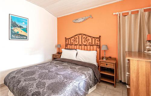 um quarto com uma cama com uma parede laranja em Beautiful Home In Noirmoutier En Lile With House Sea View em Noirmoutier-en-l'lle