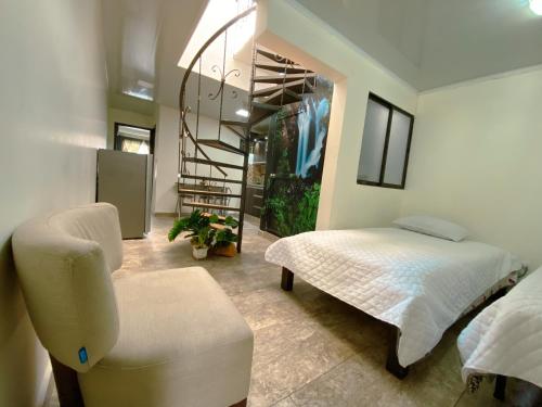 um quarto com uma cama e uma cadeira em Los Ríos em Pereira