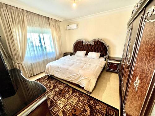 ein Schlafzimmer mit einem großen Bett und einem Fenster in der Unterkunft Cozy 3 Bedroom Apartment Near 7th Circle in Amman