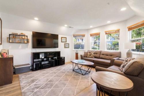 a living room with a couch and a tv at Pacifica Storybook Beach House in Pacifica