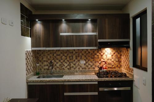 a kitchen with a sink and a stove top oven at Los Ríos in Pereira