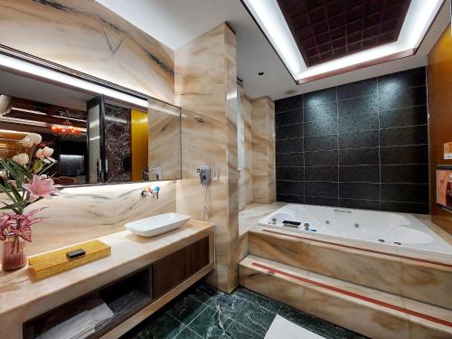 a large bathroom with a tub and a sink at Elysees Motel in Toufen
